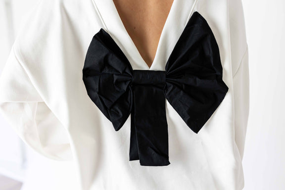 White back bow sweatshirt featuring a large black bow detail on the back for stylish comfort