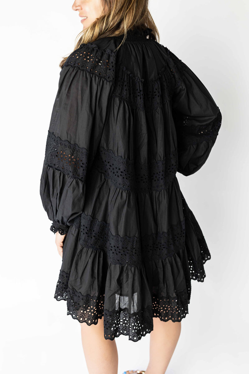 Black long sleeve eyelet mini dress with intricate cutout details and a relaxed fit