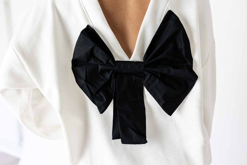 White back bow sweatshirt featuring a large black bow detail on the back for stylish comfort