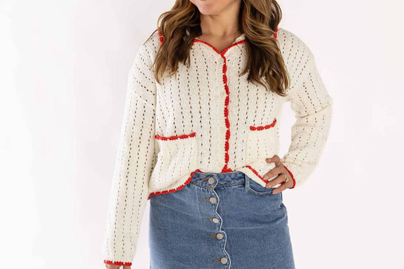Weaving Color white cardigan knit with red trim worn with blue button-up denim skirt