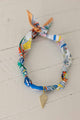 Weaving Color colorful fabric necklace with gold leaf pendant on white wooden background