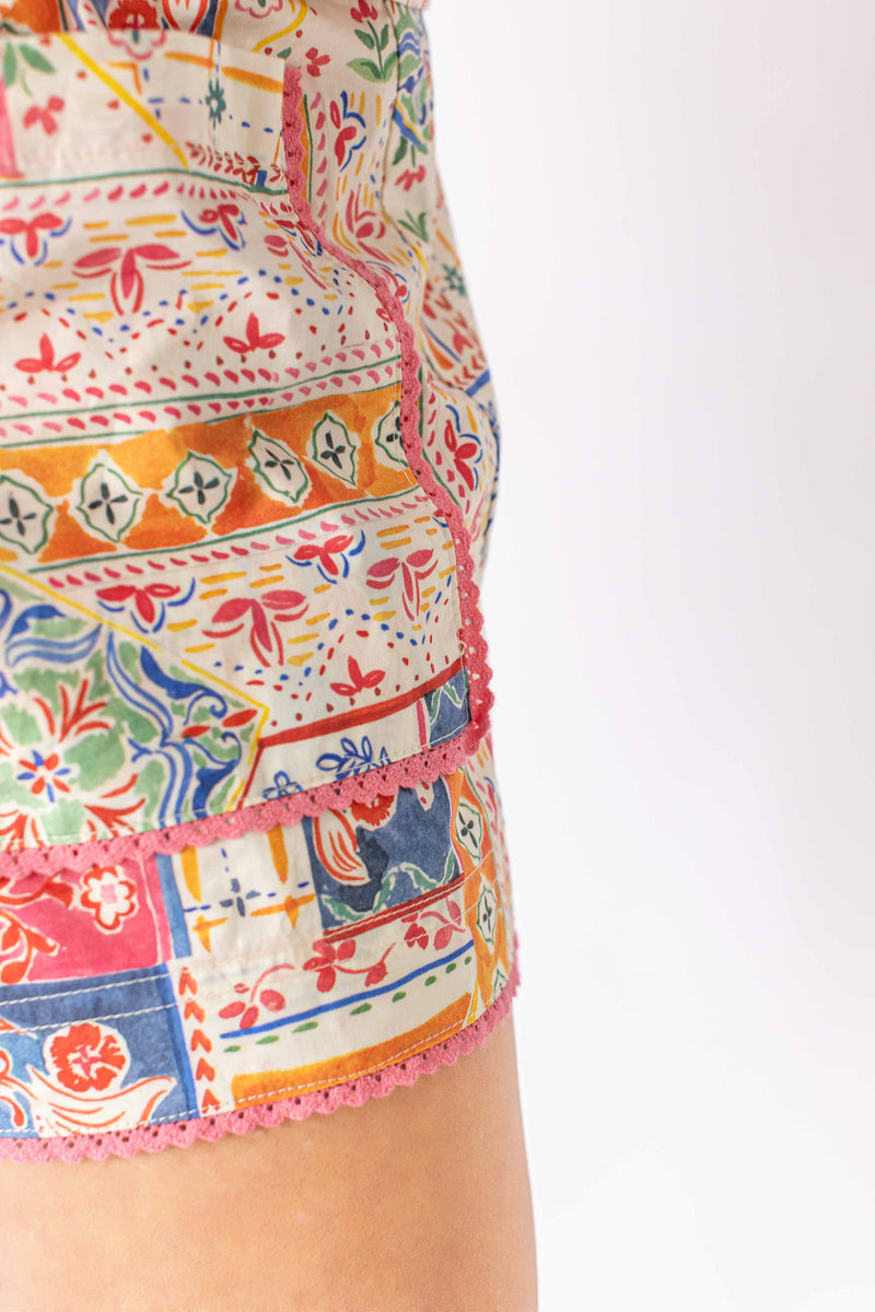 Close-up of Weaving Color colorful patchwork shorts showing detailed floral and geometric patterns with pink trim