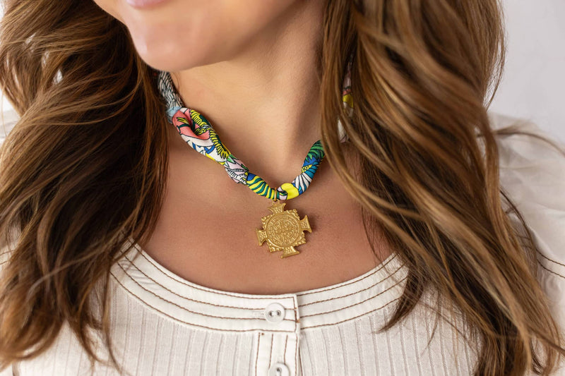 Weaving Color scarf necklace with vibrant multicolor fabric and gold pendant worn with white top