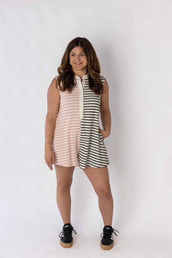 Woman wearing a sleeveless contrast stripe romper by Weaving Color with pink and black stripes