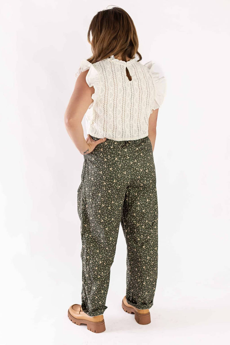 Back view of woman wearing Weaving Color floral print drawstring pants with white ruffled sleeve top