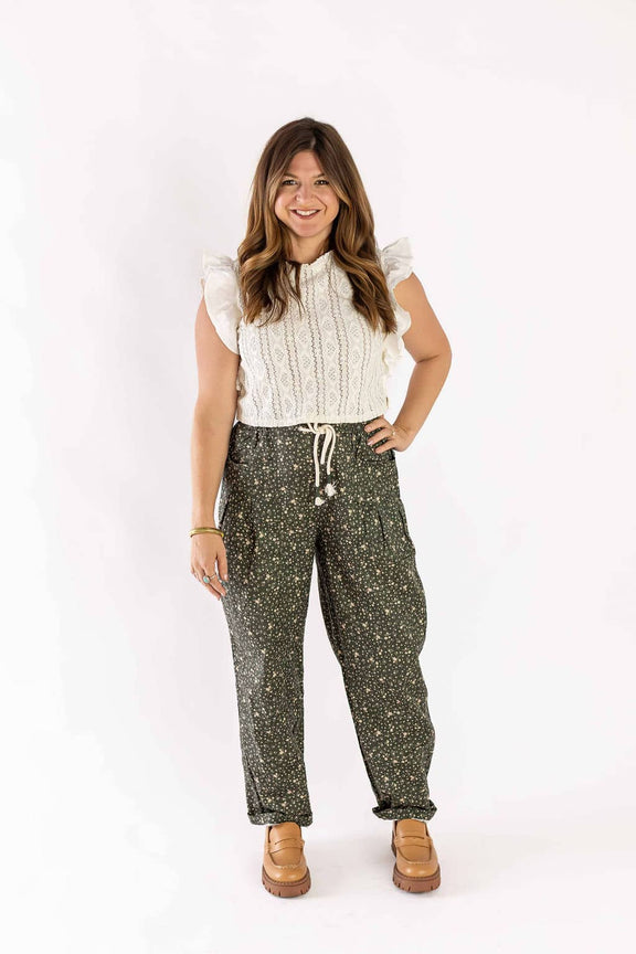 Woman wearing Weaving Color drawstring pants with floral print paired with white ruffled sleeveless top