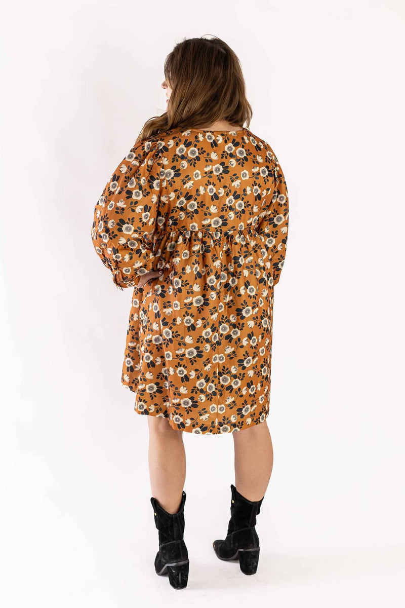 Weaving Color dress floral in orange with white flower print and long puff sleeves worn with black boots