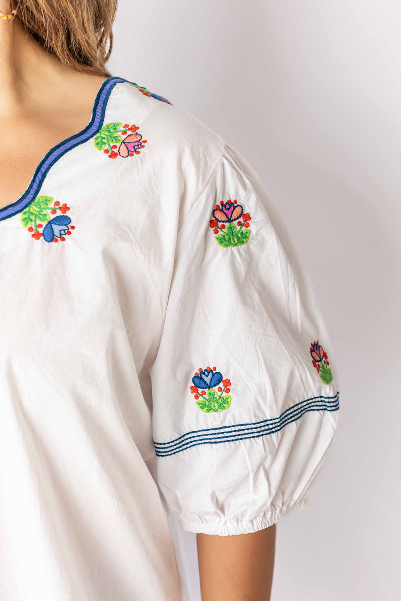 Weaving Color white embroidered peasant top with colorful floral designs on sleeves and neckline