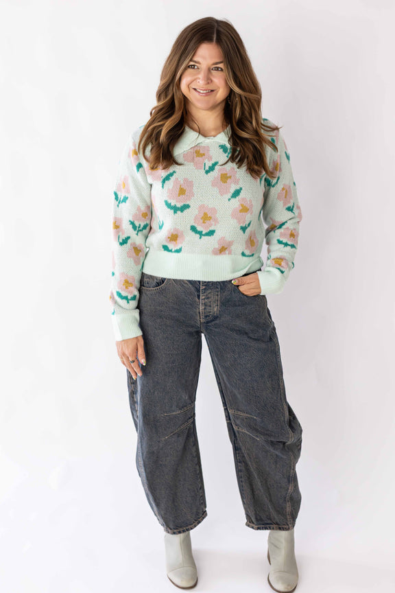 Woman wearing a Weaving Color floral detail sweater with pastel flowers and casual jeans outfit