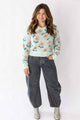 Woman wearing a Weaving Color floral detail sweater with pastel flowers and casual jeans outfit