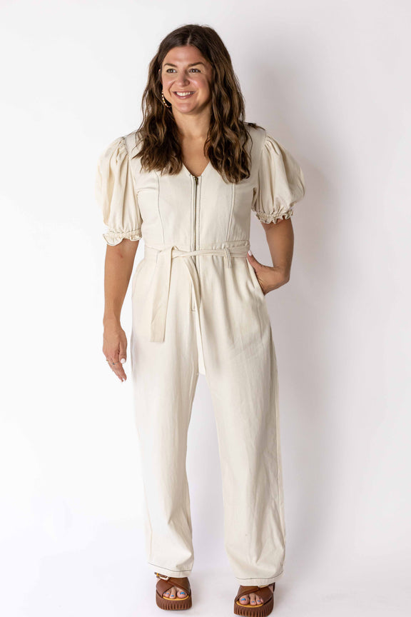 Woman wearing Weaving Color ivory puff sleeve jumpsuit with zipper front and tied waist belt