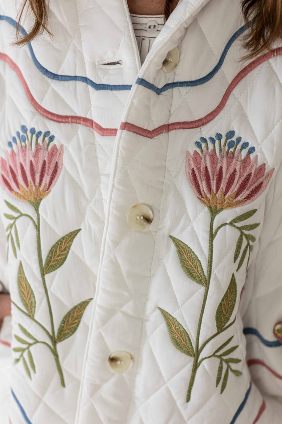Close-up of Weaving Color meadow bloom quilted jacket with floral embroidery and button closure