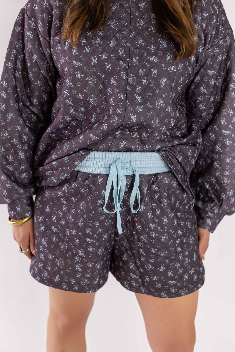 Weaving Color quilted set featuring dark floral patterned long sleeve top and matching shorts with blue waistband