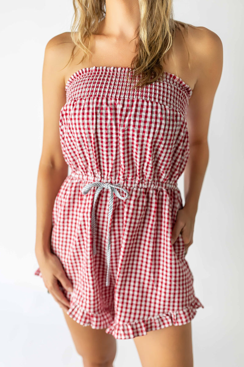 Woman wearing red checkered tube romper with elastic waist and ruffled hem from My Store