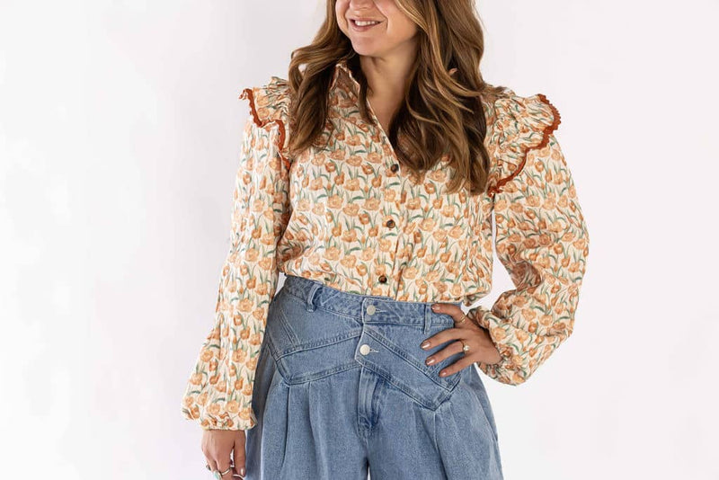 Weaving Color floral ruffle blouse with button front and puffed sleeves worn with high-waisted denim jeans
