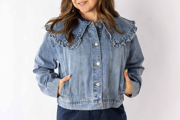 Weaving Color ruffle collar denim jacket in light blue worn by model with hands in pockets