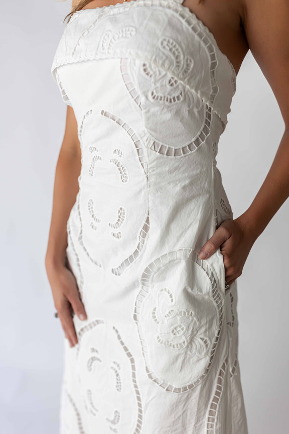 Close-up of a white crochet maxi dress with intricate floral patterns worn by a model