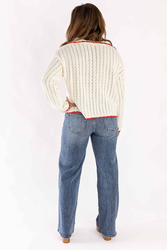 Back view of woman wearing wide leg denim jeans by Weaving Color with a white knit sweater