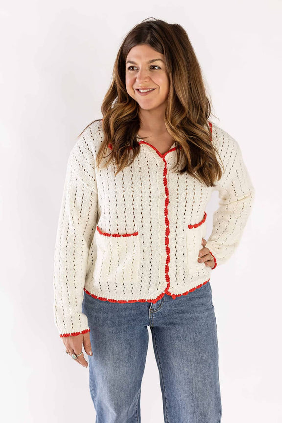 Woman wearing Weaving Color wide leg denim jeans paired with a cream cardigan with red trim