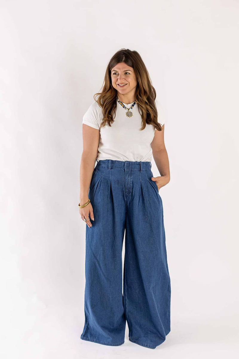 Woman wearing casual white t-shirt and blue wide-leg jeans by Weaving Color with hands in pockets