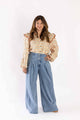 Weaving Color floral ruffle blouse with long sleeves worn by woman paired with wide-leg jeans